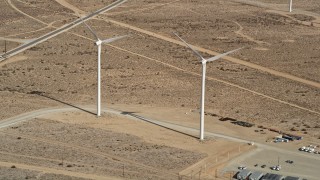 AX0006_045E - 5K aerial stock footage approach two windmills at a wind energy farm in the California desert