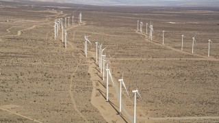 AX0006_049 - 5K aerial stock footage orbit long row of windmills at a wind farm in the desert of Antelope Valley, California