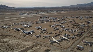 AX0006_061E - 5K aerial stock footage orbiting an aircraft boneyard in the Mojave Desert, California