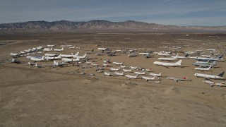 AX0006_069 - 5K aerial stock footage orbit airplanes in a desert field at an aircraft boneyard, Mojave Air and Space Port, California