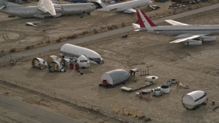 AX0006_074 - 5K stock footage aerial video orbit cabin and cockpit aircraft sections at a desert boneyard, Mojave Air and Space Port, California