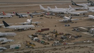 AX0006_075 - 5K aerial stock footage orbit aircraft and components at a desert boneyard in California, Mojave Air and Space Port