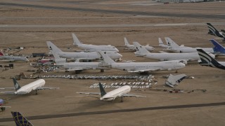 AX0006_076 - 5K aerial stock footage of jet airplanes and components at an aircraft boneyard in the desert, Mojave Air and Space Port, California