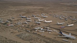 AX0006_086 - 5K aerial stock footage of airplanes and components at an aircraft boneyard, Mojave Air and Space Port, California