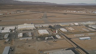 AX0006_093E - 5K stock footage aerial video orbit a row of hangars and runways at Mojave Air and Space Port, California