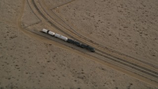 AX0006_097 - 5K aerial stock footage approach tanker train on a side track in Mojave, California