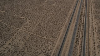AX0006_099 - 5K aerial stock footage reverse view of a Highway 14 and open desert in Antelope Valley, California