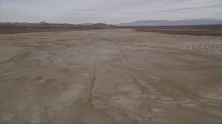 AX0006_134E - 5K aerial stock footage of flying low altitude over a desert dry lake, El Mirage Lake, California