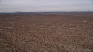 AX0006_155 - 5K aerial stock footage pan across open desert to reveal the small town of Helendale, California