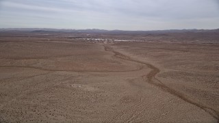AX0006_156 - 5K aerial stock footage pan across the Mojave Desert to reveal the small town of Helendale, California