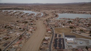 AX0006_164E - 5K stock footage aerial video fly over small desert town with two lakes in Helendale, California
