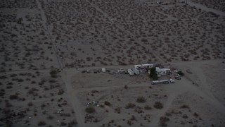 AX0007_024 - 5K aerial stock footage tilt and fly over RVs parked in the Mojave Desert at twilight, California