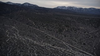 AX0007_041 - 5K aerial stock footage of flying over rural homes in the Mojave Desert at twilight, California