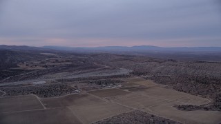 AX0008_002 - 5K aerial stock footage approach a dry riverbed at twilight in the Mojave Desert, California
