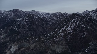 AX0008_007 - Aerial stock footage of 5K aerial  video orbiting snowy San Gabriel Mountains in wintertime at twilight, California