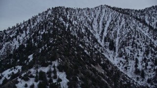 AX0008_009 - 5K aerial stock footage orbit snowy mountain ridge and tilt to San Gabriel Mountains peak at twilight, California