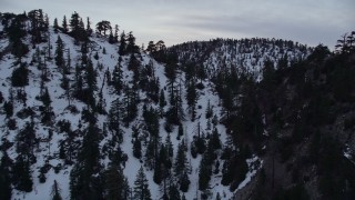 AX0008_011 - 5K aerial stock footage approach and fly over snowy ridge in the San Gabriel Mountains at twilight, California