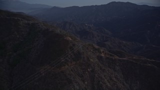 AX0008_046 - 5K aerial stock footage orbit power lines on a slope at twilight in the San Gabriel Mountains, California