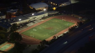 AX0008_069 - 5K stock footage aerial video orbit a football field during nighttime practice at La Cañada Flintridge, California