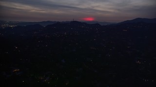 AX0008_070 - 5K aerial stock footage of a red glow in clouds above hillside homes in La Cañada Flintridge at night, California