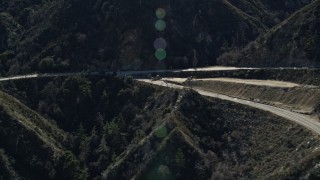 AX0009_020 - 5K aerial stock footage of three motorcycles on a mountain road in the San Gabriel Mountains, California