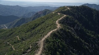 AX0009_038E - 5K aerial stock footage orbit dirt road on a ridge in the San Gabriel Mountains, California