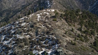 AX0009_053E - 5K aerial stock footage fly over ridge with snow on shady side in the San Gabriel Mountains in winter, California