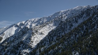AX0009_058 - 5K stock footage aerial video pan across a snowy peak in the San Gabriel Mountains in wintertime, California