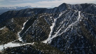 AX0009_066 - 5K aerial stock footage approach snowy slopes of Mount Baldy Ski Lifts, California