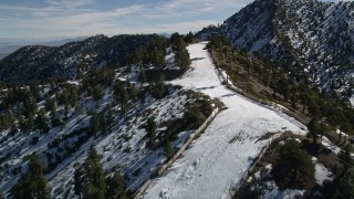 AX0009_067E - 5K aerial stock footage of steep ski runs at Mount Baldy Ski Lifts in California with winter snow