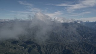 AX0009_077E - 5K aerial stock footage fly through wispy clouds over the San Bernardino Mountains, California