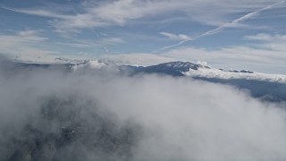 AX0009_084E - 5K aerial stock footage fly over top of a cloud with a view of distant San Bernardino Mountains, California