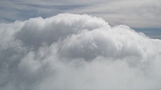 AX0009_101 - 5K aerial stock footage fly over thick clouds to reveal summit of San Bernardino Mountains peak, California