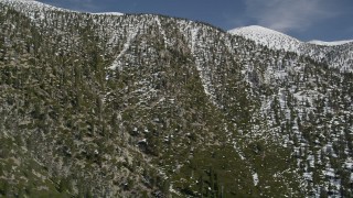 AX0009_115 - 5K aerial stock footage tilt up a San Bernardino Mountains slope with light winter snow, California