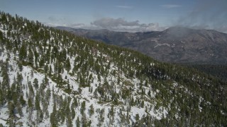 AX0009_122 - 5K aerial stock footage fly over mountain slope covered in winter snow and evergreens, San Bernardino Mountains, California