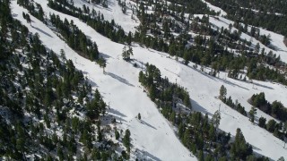 AX0009_133 - 5K aerial stock footage orbit skiers on slopes at the winter ski resort of Snow Summit, California