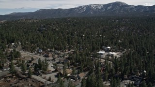 AX0010_002 - 5K aerial stock footage approach forest with snow at the edge of Big Bear Lake, California