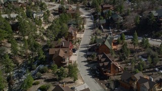 AX0010_010E - 5K aerial stock footage orbit and fly over homes near Big Bear Lake with patches of winter snow, California
