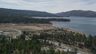 AX0010_012 - 5K aerial stock footage tilt up from small town homes to reveal Big Bear Lake, California