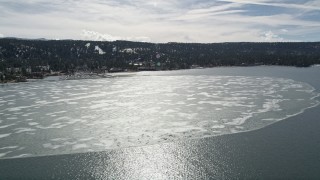 AX0010_016 - 5K aerial stock footage of a large patch of winter ice on Big Bear Lake, California