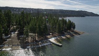 AX0010_021E - 5K aerial stock footage tilt and reveal waterfront homes with light snow at Big Bear Lake, California