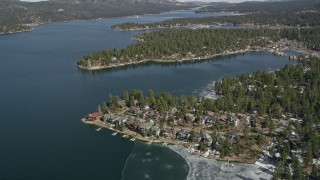 AX0010_030 - 5K aerial stock footage tilt to waterfront homes on the shore of Big Bear Lake in winter, California