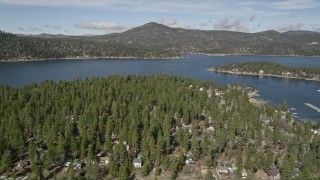 AX0010_032 - 5K aerial stock footage of Big Bear Lake seen from town on the shore in winter, California
