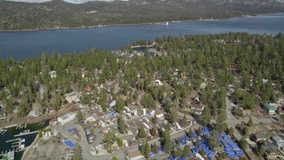 AX0010_033E - 5K aerial stock footage tilt and approach homes and town on the shore of Big Bear Lake, California