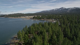 AX0010_036 - 5K aerial stock footage tilt to reveal and approach shore of Big Bear Lake with light winter snow, California