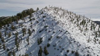 AX0010_067 - 5K aerial stock footage fly over snowy mountains to approach low cloud bank in the San Bernardino Mountains, California