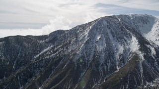 AX0010_068 - 5K aerial stock footage orbit snowy peak in the San Jacinto Mountains in winter, California