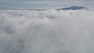 AX0010_073 - 5K aerial stock footage approach clouds and a tall San Jacinto Mountains peak in the distance, California