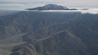 AX0010_084 - 5K aerial stock footage tilt from windmills to reveal a peak in the San Jacinto Mountains, California
