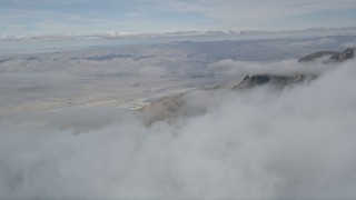 AX0010_094 - 5K aerial stock footage of distant Little San Bernardino Mountains seen from layer of clouds, California